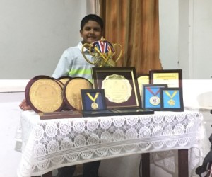 Aryaman Singh proudly poses with the many trophies and medal he won at various Golf tournaments. 