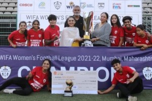 PIFA Sports players, Head Coach Nirvan Shah and Manager and Founder Anjali Shah receive the Champions Trophy from Chief guest, Chhatrapati Madhureema Raje, during the prize distribution function of the WIFA Women’s Football League 2021-2022 .