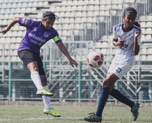 S.P. Football Academy captain and ace striker Delfiya Pereira (left) takes a shot at goal while Next Sports Academy defender Astha Tandel takes evasive action .